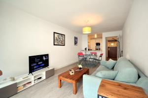 a living room with a blue couch and a tv at Charmant 2 Pièces au calme in Menton