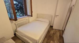 een kleine slaapkamer met een klein bed in een kamer met een raam bij Villetta del Prato in Roccaraso