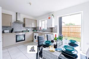 - une cuisine avec une table et des plats bleus dans l'établissement 4 Bedroom House Free Parking By NYOS PROPERTIES Short Lets & Serviced Accommodation Manchester, à Manchester