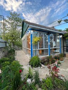 a house with blue trim and plants in the yard at Me and grandfather-მე და პაპა in Dedoplis Tskaro