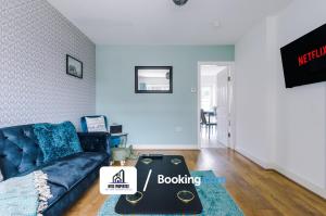 - un salon avec un canapé bleu et une table dans l'établissement 4 Bedroom House Free Parking By NYOS PROPERTIES Short Lets & Serviced Accommodation Manchester, à Manchester