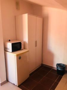eine Küche mit einer Mikrowelle auf dem Kühlschrank in der Unterkunft NN Guest House in Coimbra