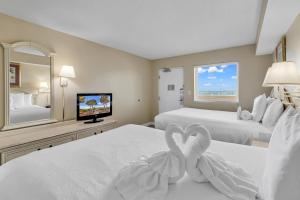 a hotel room with two beds and a television at Oceanfront Condo Camelot By the Sea in Myrtle Beach +30 photos