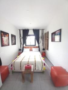 a bedroom with a bed and two red chairs at Esprit nomade, piscine privée et jardin - SERVICES ALL-INCONCIERGERIE in Douar Bellouk