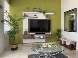 a living room with a tv and a glass table at Granero Kenyard in Aguadilla in Moca