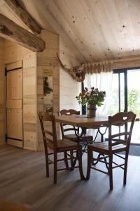 - une salle à manger en bois avec une table et des chaises dans l'établissement L'orée du bois gaubau, à Saint-Georges-sur-Layon