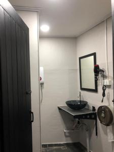 a bathroom with a sink and a mirror at Batman guesthouse in Vientiane