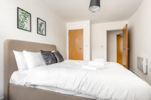 una camera da letto con un grande letto con lenzuola bianche di Bright 1 Bedroom Apartment in Central Sheffield a Sheffield