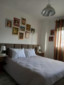 ein Schlafzimmer mit einem großen Bett mit Bildern an der Wand in der Unterkunft Casa do Artista in Vila Verde