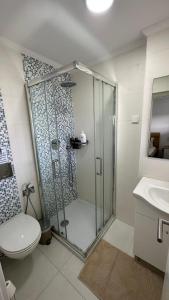 uma casa de banho com um chuveiro, um WC e um lavatório. em Quarto Aeroporto em Lisboa