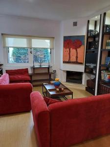 a living room with two red couches and a table at Anatoli apartment in Mytilene