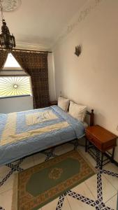 a bedroom with a bed and a table and a window at Residence Koutoubienne in Marrakech