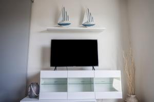 a white entertainment center with a flat screen tv at OurMadeira - Vila Diana in Porto Santo