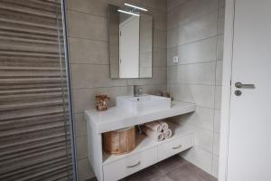 a bathroom with a sink and a mirror at OurMadeira - Vila Diana in Porto Santo +30 photos