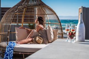 a woman sitting in a hammock talking on a cell phone at Anasa Luxury Villas in Kokkini Khanion