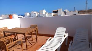 a balcony with a table and chairs on a roof at Namasté in Puerto de las Lajas