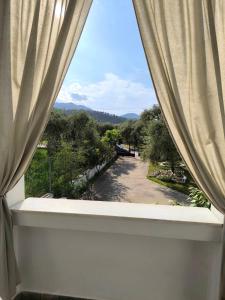 a window with a view of a park seen through it at Anna's Garden House in Limenas