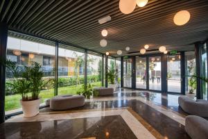 a lobby with chairs and plants in a building at Astria Brasil - Complex Novum in Olimp