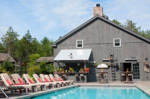 un granero con sillas junto a una piscina en Hidden Pond Resort en Kennebunkport