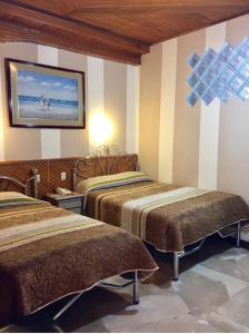 Hotel Metropolitano tesisinde bir odada yatak veya yataklar