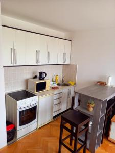 a kitchen with white cabinets and a stove top oven at Venus Apartman in Brčko