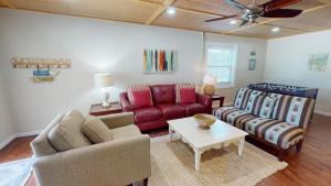 un salon avec un canapé rouge et une table dans l'établissement 4-B 12th Street by Tybee Vacation Rentals, à Tybee Island