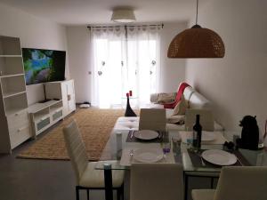 sala de estar con mesa, sillas y TV en Apartment 2 bedrooms and terrace, en La Tejita