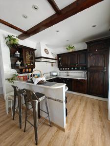 uma cozinha com armários de madeira e uma mesa com cadeiras em A Casa do Choco em Redondela