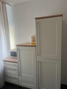 een keuken met een witte kast en een koelkast bij Apartment 1 in Duisburg-Mitte, Altstadt in Duisburg