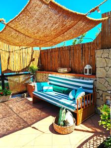 eine blaue Couch auf einer Terrasse mit einem Zaun in der Unterkunft Mediterranea Casa del Capricorno in Massa Lubrense