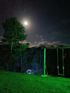 a full moon over a field at night at CascataDiamantePousada in Laurentino