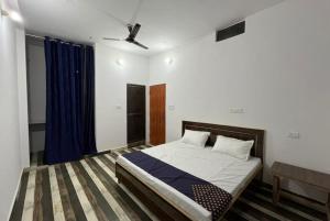 1 dormitorio con cama y cortina azul en Goroomgo Hotel Kashi Nest Varanasi - A Peacefull Stay & Parking Facilities en Varanasi