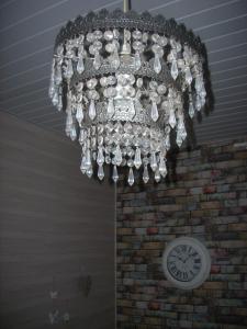 a chandelier hanging from a brick wall with a clock at Hotel du Château in Nantes