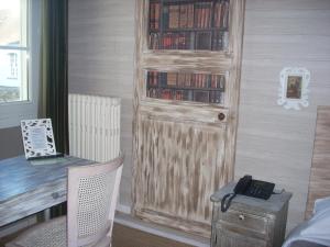 a room with a desk and a wooden door with books at Hotel du Château in Nantes