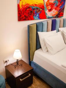 1 dormitorio con 1 cama y 1 mesa con lámpara en Colorway Apartment en Belgrado