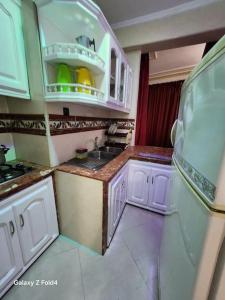 a small kitchen with white cabinets and a sink at complexe printemps n 155 et 3 in Tangier