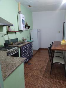 a kitchen with a stove and a table and a refrigerator at yusulpayki in Termas de Río Hondo