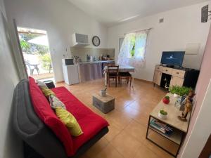 ein Wohnzimmer mit einem roten Sofa und einem Tisch in der Unterkunft chez Béatrice in Porto-Vecchio