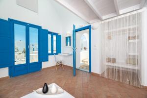 bagno con porte blu, vasca e lavandino di Seaside by Manos a Kamari