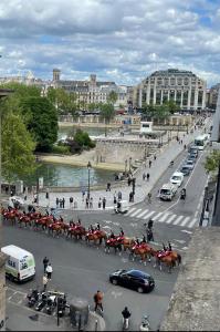 a group of horses and people on a city street at VUE SUR LA SEINE in Paris