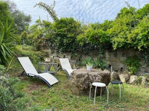 a group of chairs and a table and a rock at chez Béatrice in Porto-Vecchio