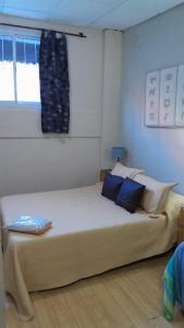 1 dormitorio con 1 cama grande con almohadas azules en Departamentos Avenida San Martin en Mendoza