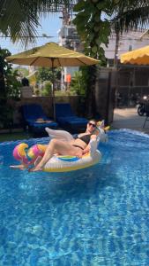 un hombre en traje de baño tirado en una balsa en una piscina en Hoi An Discovery Villa, en Hoi An