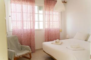 桑盧卡爾－德巴拉梅達的住宿－Magnífico dúplex de 3 dormitorios con vistas a la playa，卧室配有床、椅子和窗户。