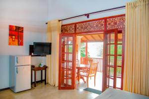 a kitchen with a door open to a patio with a table at Lagoon Bentota Resort in Bentota