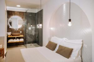 a bedroom with a white bed and a shower at Dirium - exclusive rooms in Monopoli