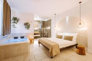 Dirium - exclusive rooms في مونوبولي: غرفة نوم مع سرير وحوض استحمام