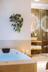 a bathroom with a tub with a plant on the wall at Dirium - exclusive rooms in Monopoli