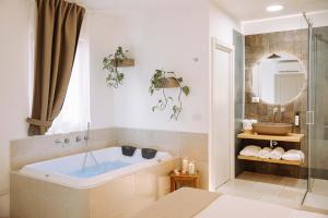 a bathroom with a bath tub and a mirror at Dirium - exclusive rooms in Monopoli