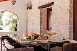 una mesa con una bandeja de fruta y copas de vino en Villa Fantaxat by Abahana Villas, en Benissa